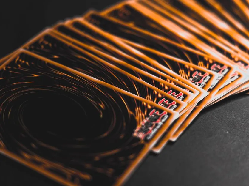 A fanned spread of trading cards on a dark surface