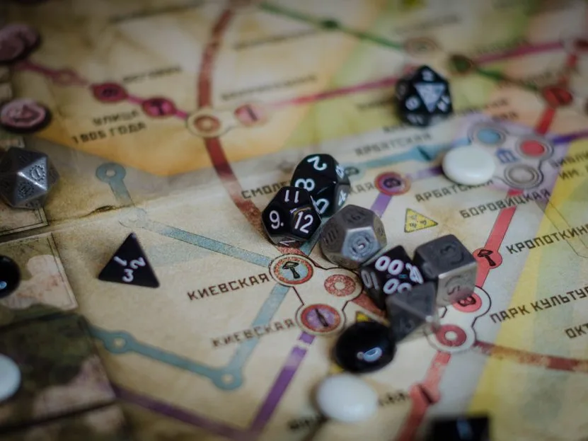 Polyhedral roleplaying dice scattered across an illustrated map