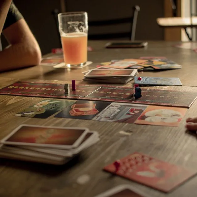 A table of card games in progress with drinks alongside