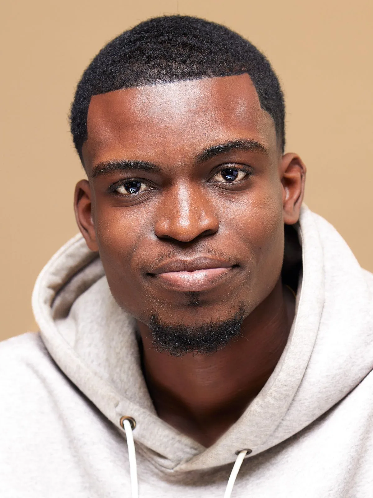 Devon, the events lead, in a cream hoodie against a warm background